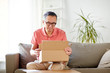 © Syda Productions - man opening parcel box at home