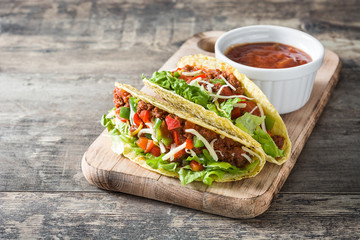 Wall Mural - Traditional Mexican tacos with meat and vegetables on wooden background
