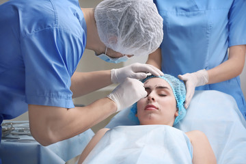 Plastic surgeon operating patient in clinic