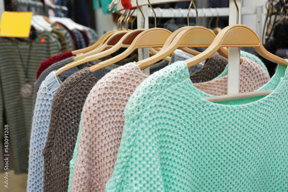 Rack with different clothes in modern shop