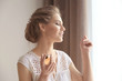 © Africa Studio - Beautiful young woman with bottle of perfume near window at home