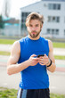 © be free - athletic bearded man with muscular body holds cell phone