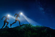 Night trail runner of men and women running on the mountain.at night milky way