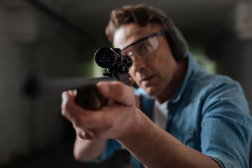 Wall Mural - Handsome professional sniper looking into the optical sight