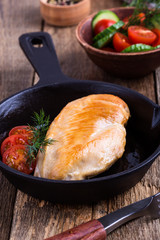 Canvas Print - Fried chicken breast on skillet with tomatoes