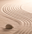© kikkerdirk - zen stone garden with meditation stone for concentration and spirituality. Sand with raked lines, sandy texture with copy space. Spa wellness or yoga concept.