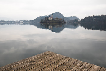 beautiful island with church on lake bled in cloudy sky, slovenia