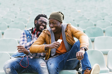 two black race friends having fun with mobile.