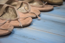 Small Used Shoes For Dance, Isolated On Wooden Background.