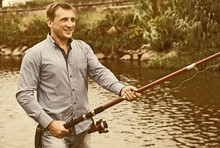 Man Fishing Using Rod On Lake