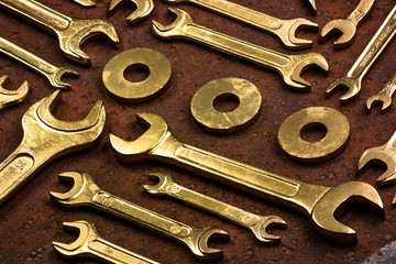 Set of golden repair tools on rusty background