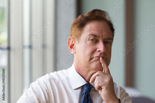 Fotomural Stern mature employer touching chin