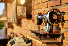 Handicraft. Vintage Sewing Machine With Brick Wall Background.