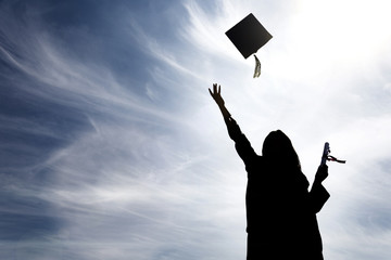 Graduate students tossing up hats over blue sky