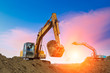 excavator in construction site on sunset sky background