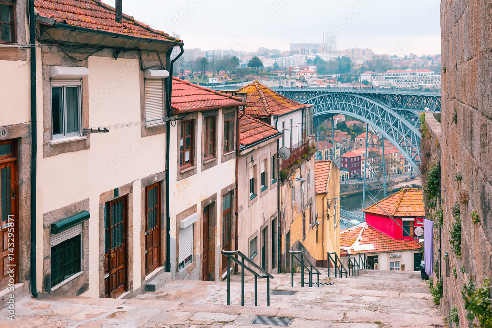 Traditional old houses in Ribeira and stairs down to the river Douro, Dom Luis I or Luiz I iron bridge on the background, Porto, Portugal - obrazy, fototapety, plakaty 