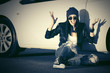 © Wrangler - Angry fashion punk woman sitting next to her car
