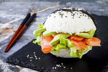 Wall Mural - Homemade asian style gluten free sushi salmon burger. Sushi-food hybrids trend. Bright blue background with copy space