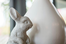 Closeup Cute Cement Rabbit Statue For Decorate In Coffee Shop Background Under Window Light