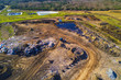 Aerial view of municipal landfill site. Typical waste treatment technology top view. Garbage pile and toxic lakes with dangerous chemicals in trash dump.
