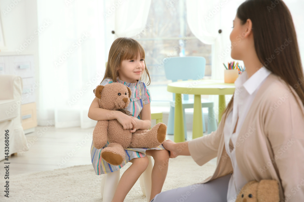 Young child psychologist working with little girl
