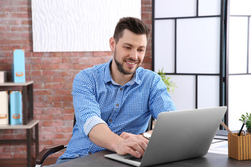 Poster - Handsome young man working with laptop in office