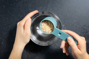 Wall Mural - Putting brown rice into bowl with water