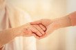 © Africa Studio - Old and young women holding hands on blurred background, closeup