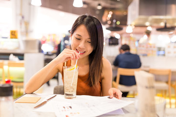 Sticker - Woman enjoy soft drink and choosing on menu in restaurant