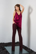 © boomeart - Attractive fashion model in pants and blouse on straps touching her hair.