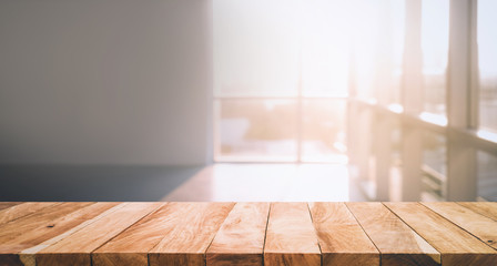 Wood table top with blur sunlight in glass window in room building background.For montage product display or key visual layout  background.