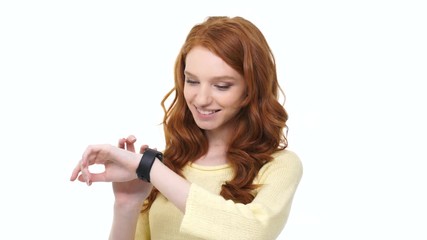 Poster - Smiling young woman with long curly red hair receives message on smartwatch isolated over white