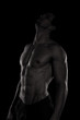 © Milkica - Muscular and defined six pack abs on handsome male model posing on black background