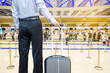business man walking travel bag by an international airport