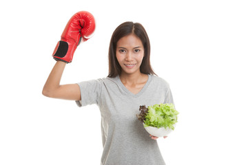 Young Asian woman with boxing glove and salad.