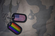 army blank, dog tag with flag of united states of america and gay rainbow flag on the khaki texture background. military concept