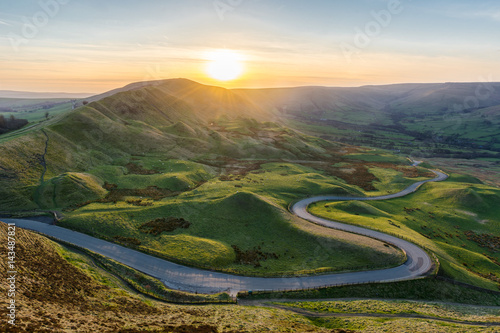 Cuadros en Lienzo Puesta de sol en Mam Tor en el Peak District con largo camino sinuoso que lleva a través del valle