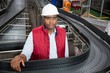 © Wavebreak Media - Male employee standing by conveyor in factory