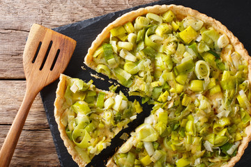 Canvas Print - Sliced savory leek tart with cheese close-up on the table. Horizontal top view