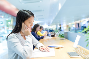 Sticker - Woman talk to mobile phone and studying on the note in coffee shop