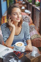 Wall Mural - Young woman sitting indoor in urban cafe