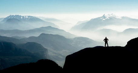 Poster - Spectacular mountain ranges silhouettes. Man reaching summit enjoying freedom.