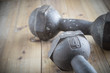 © oatography - The old dumbbell on the wooden floor.