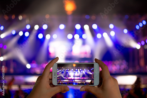Fotografie, Obraz Image of hands using camera phone to take pictures and videos at live concert
