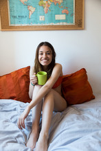 Cheerful Girl With Cup On Bed