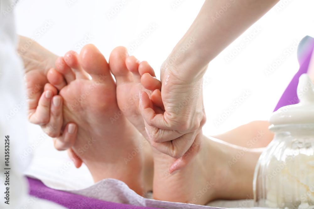 Relaksujący masaż stóp. Kobieta w salonie kosmetycznym na zabiegu pedicure z masażem. - obrazy, fototapety, plakaty 