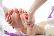 Relaksujący masaż stóp. Kobieta w salonie kosmetycznym na zabiegu pedicure z masażem.