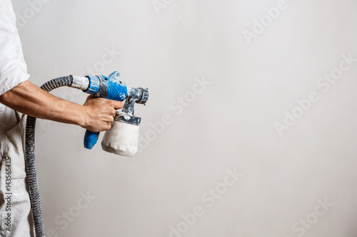 Worker Painting Wall With Spray Gun In White Color Buy This