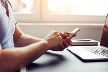 Wall Mural - man using smartphone in the office at sunset