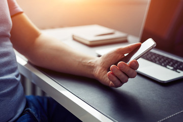 Wall Mural - close up man holding smartphone in the office at sunset